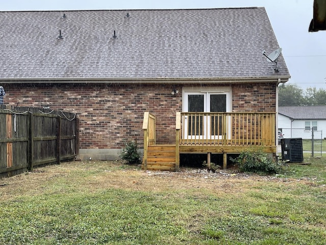 back of property featuring central AC unit, a yard, and a wooden deck