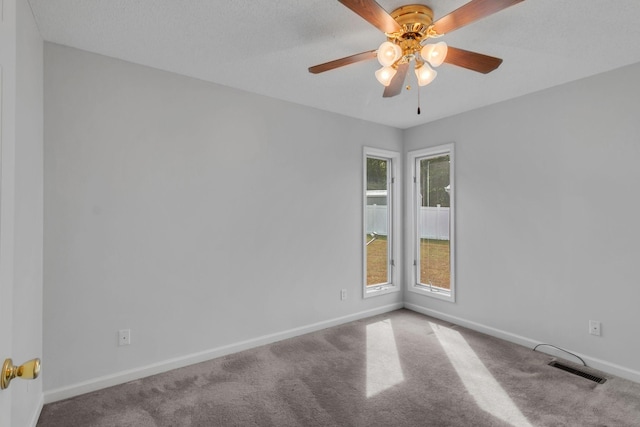 carpeted empty room with ceiling fan and a textured ceiling