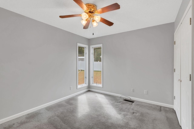 carpeted empty room featuring ceiling fan