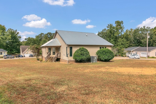 rear view of house with a yard and central AC