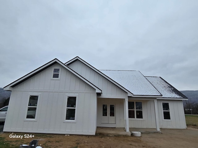 view of front facade featuring board and batten siding and a shingled roof