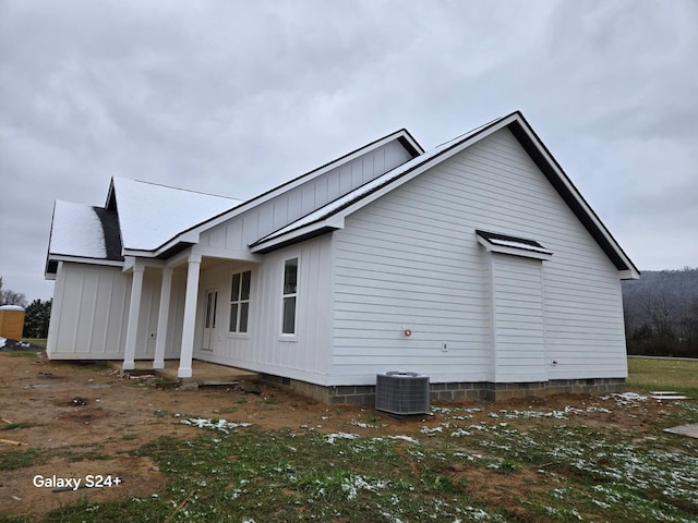 view of property exterior with board and batten siding and central air condition unit