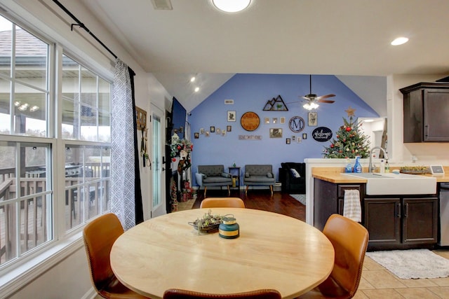 dining area with ceiling fan, light hardwood / wood-style flooring, sink, and vaulted ceiling