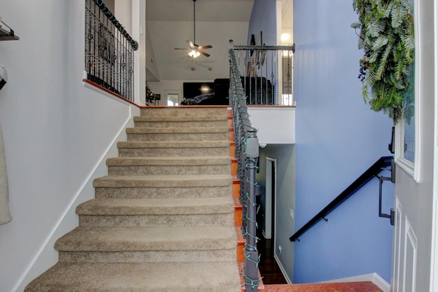 staircase featuring hardwood / wood-style floors, vaulted ceiling, and ceiling fan