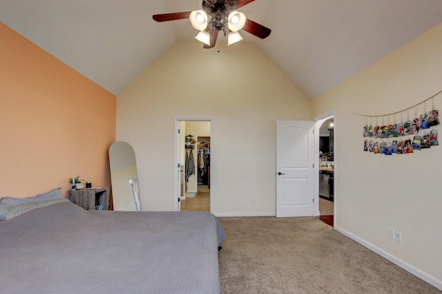 carpeted bedroom with ceiling fan, a walk in closet, and high vaulted ceiling