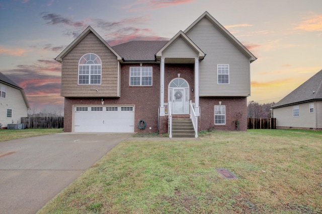 raised ranch with a lawn, central AC, and a garage