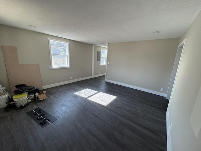 unfurnished room with dark hardwood / wood-style flooring and a textured ceiling