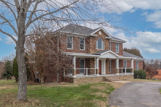 view of front of house featuring covered porch and a front lawn