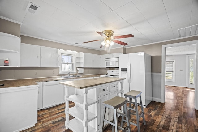 kitchen with sink, white cabinets, dark wood-type flooring, and white appliances