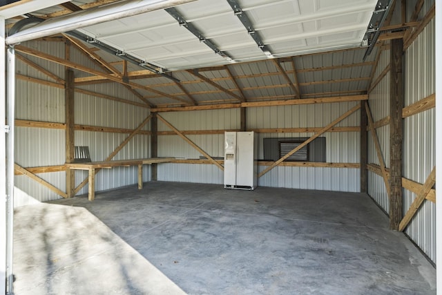 garage featuring white fridge with ice dispenser