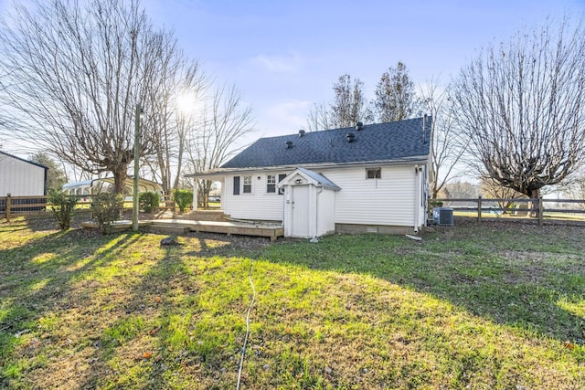 back of property featuring a deck, cooling unit, and a lawn