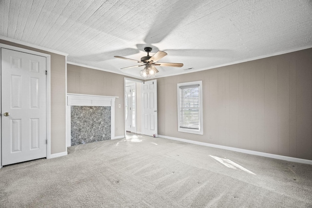 unfurnished living room with ceiling fan, crown molding, and carpet floors