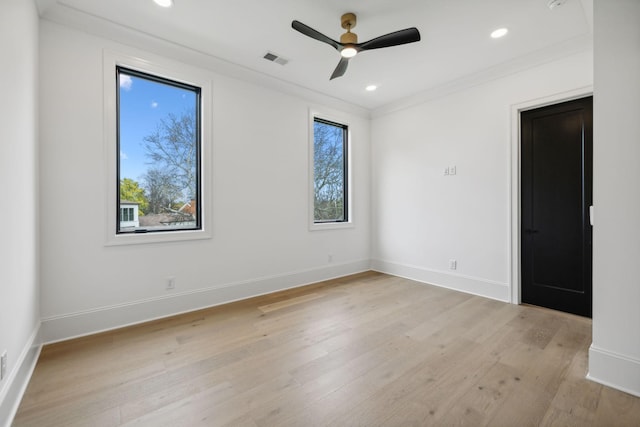 empty room with ceiling fan, crown molding, a wealth of natural light, and light hardwood / wood-style flooring