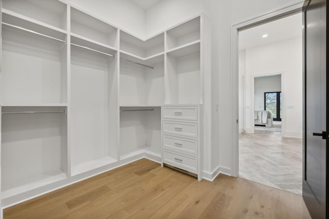 walk in closet with light hardwood / wood-style flooring