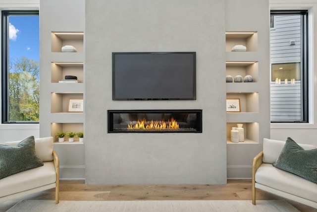 sitting room with light hardwood / wood-style floors and built in features