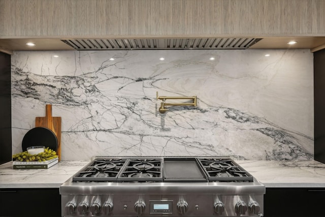 kitchen with premium range hood, light stone counters, and stainless steel range oven