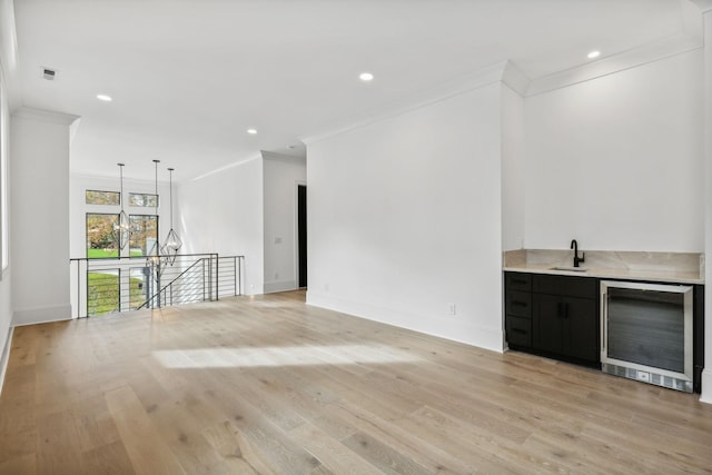 bar featuring wine cooler, sink, light hardwood / wood-style floors, and ornamental molding