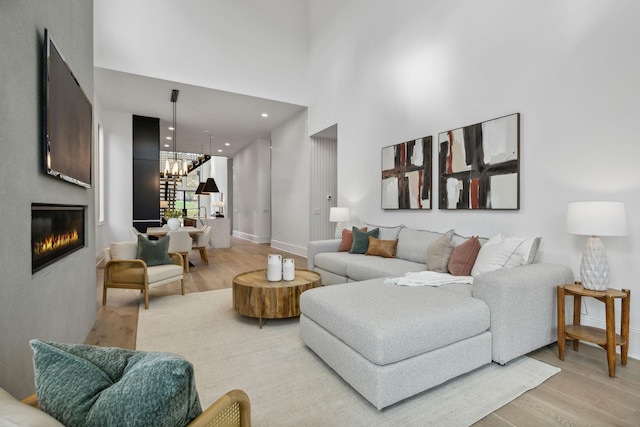 living room with a high ceiling and light wood-type flooring