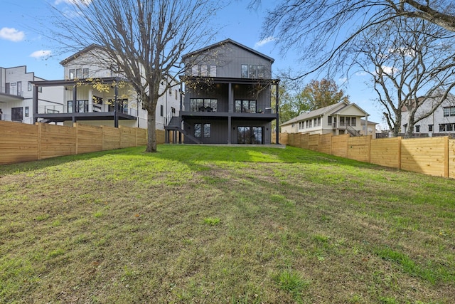 back of house featuring a lawn and a balcony