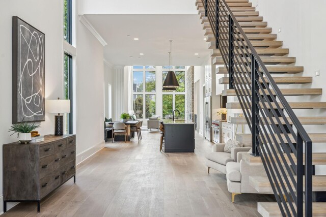 interior space with crown molding, sink, a healthy amount of sunlight, and light hardwood / wood-style floors