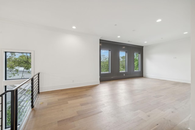 spare room featuring light hardwood / wood-style flooring and crown molding