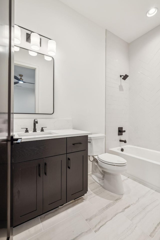 full bathroom featuring vanity, ceiling fan, toilet, and washtub / shower combination