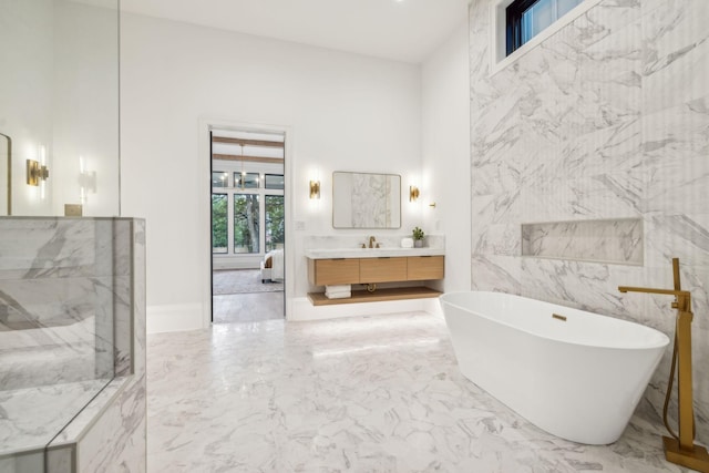 bathroom featuring a bathing tub, vanity, and tile walls