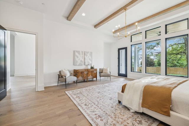 bedroom with beam ceiling, french doors, light wood-type flooring, and an inviting chandelier