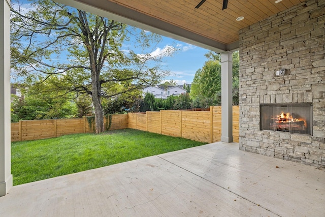 view of patio / terrace with an outdoor stone fireplace and ceiling fan