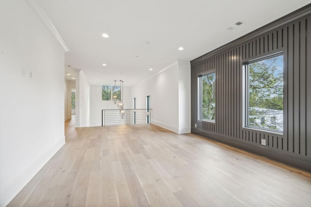 unfurnished room with light hardwood / wood-style flooring and crown molding