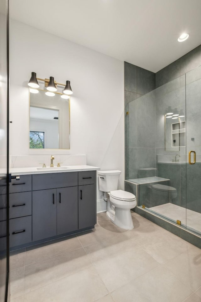 bathroom with tile patterned floors, vanity, toilet, and a shower with shower door