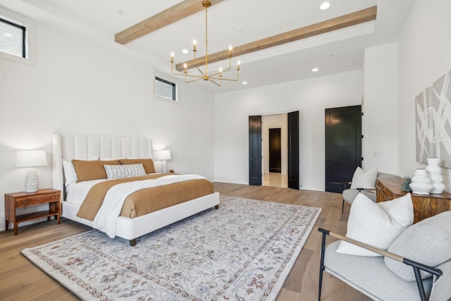 bedroom with beamed ceiling, light hardwood / wood-style flooring, and an inviting chandelier