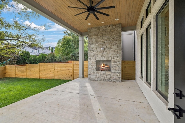 view of patio featuring an outdoor stone fireplace and ceiling fan