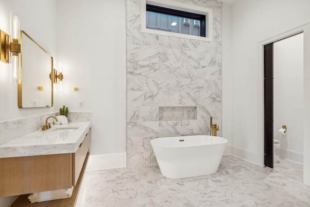 bathroom with a tub to relax in, vanity, tile walls, and toilet