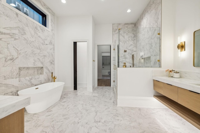 bathroom with vanity, tile walls, and shower with separate bathtub