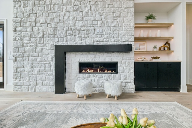 room details featuring wood-type flooring and a stone fireplace