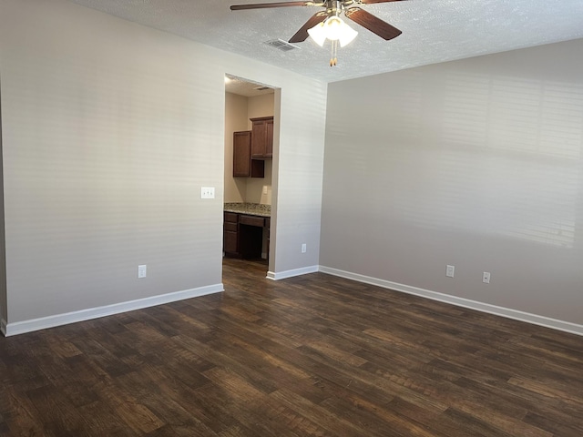 unfurnished room featuring a textured ceiling, ceiling fan, and dark wood-type flooring