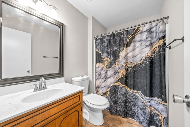 bathroom featuring toilet, vanity, a textured ceiling, and hardwood / wood-style flooring