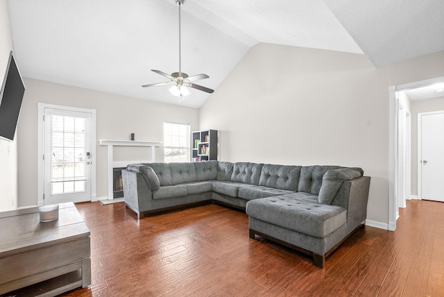 living room with hardwood / wood-style floors, high vaulted ceiling, ceiling fan, and a healthy amount of sunlight