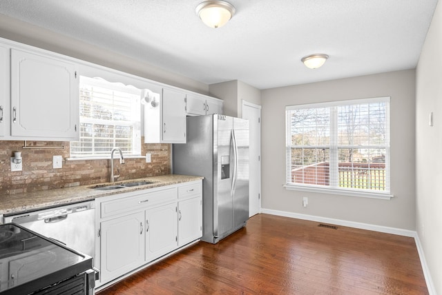 kitchen with white cabinets, plenty of natural light, sink, and stainless steel appliances