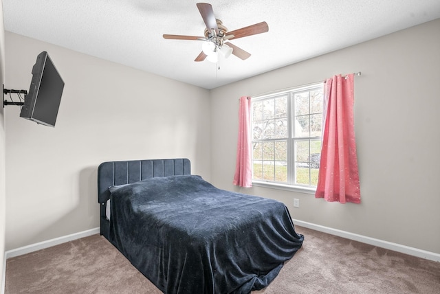 bedroom featuring carpet flooring, a textured ceiling, and ceiling fan