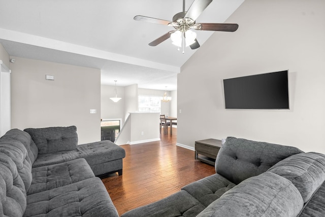 living room featuring ceiling fan with notable chandelier, dark wood-type flooring, and lofted ceiling