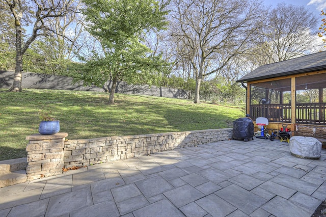 view of patio featuring a sunroom and a grill