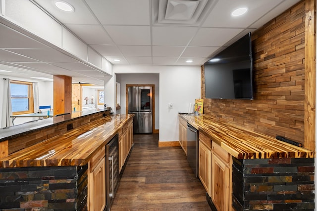 bar with dishwasher, dark wood-type flooring, beverage cooler, wooden counters, and a paneled ceiling