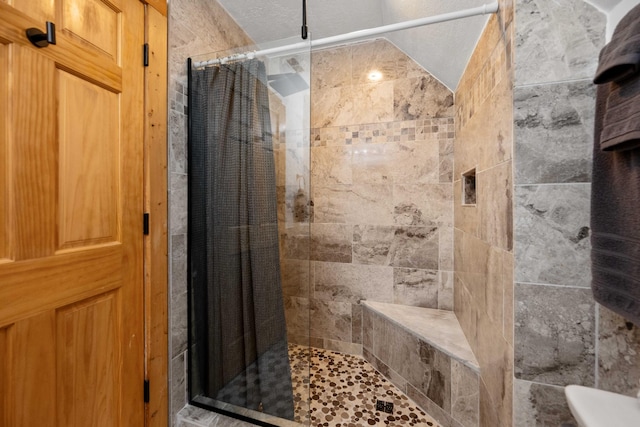 bathroom featuring a shower with shower curtain and a textured ceiling