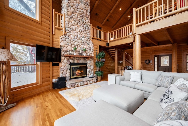 living room featuring a wealth of natural light, a fireplace, wooden ceiling, and hardwood / wood-style flooring