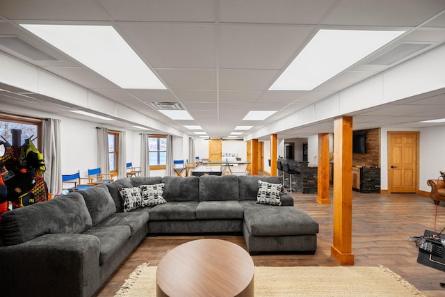 living room with a paneled ceiling, hardwood / wood-style flooring, and plenty of natural light