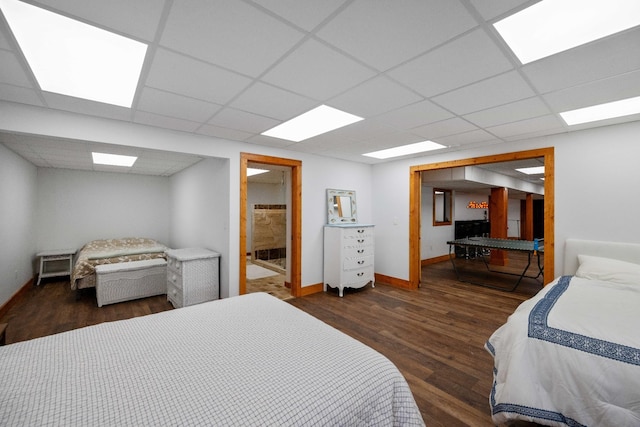 bedroom with dark hardwood / wood-style flooring and a paneled ceiling