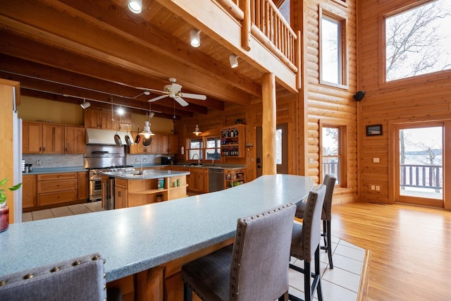 kitchen featuring a center island, light wood-type flooring, decorative light fixtures, track lighting, and appliances with stainless steel finishes