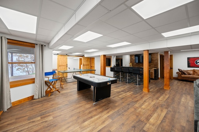 playroom with hardwood / wood-style floors, a barn door, and a drop ceiling